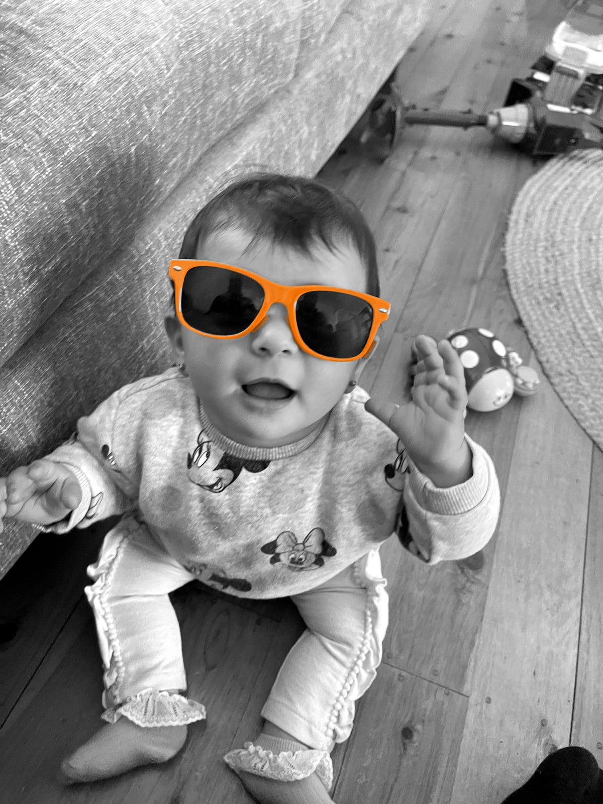 Baby in orange sunglasses, black and white with orange frames